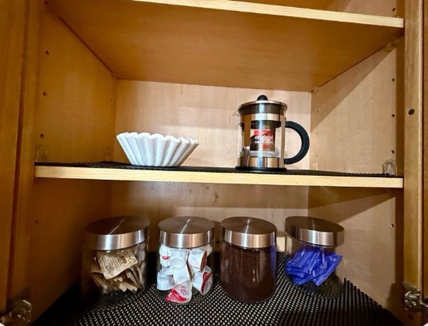 Coffee cabinet with French press, filters, coffee, creamer and sugar