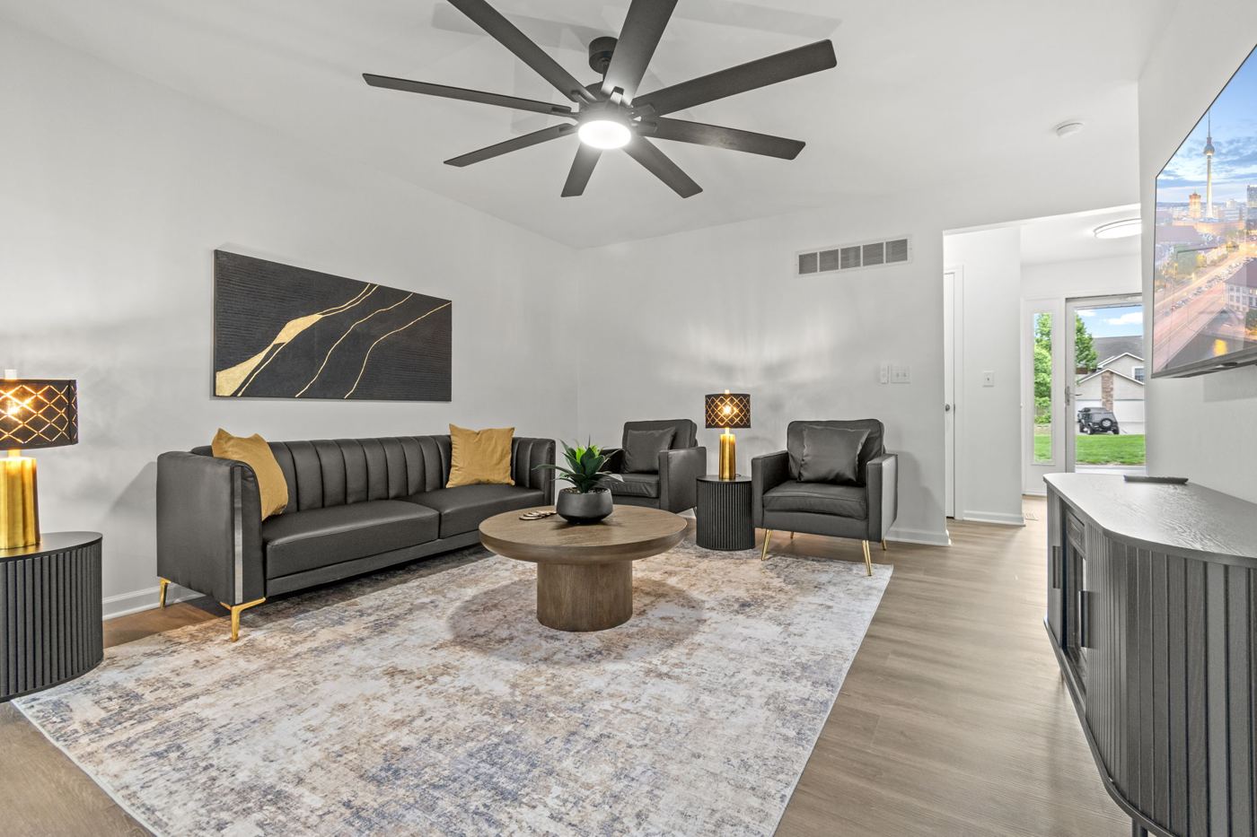 Living room with leather sofa, armchairs and round coffee table