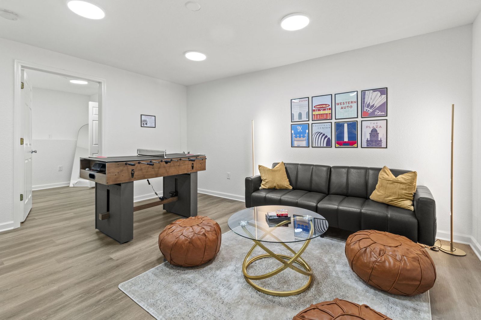 Basement lounge with leather sofa, game table and ottomans