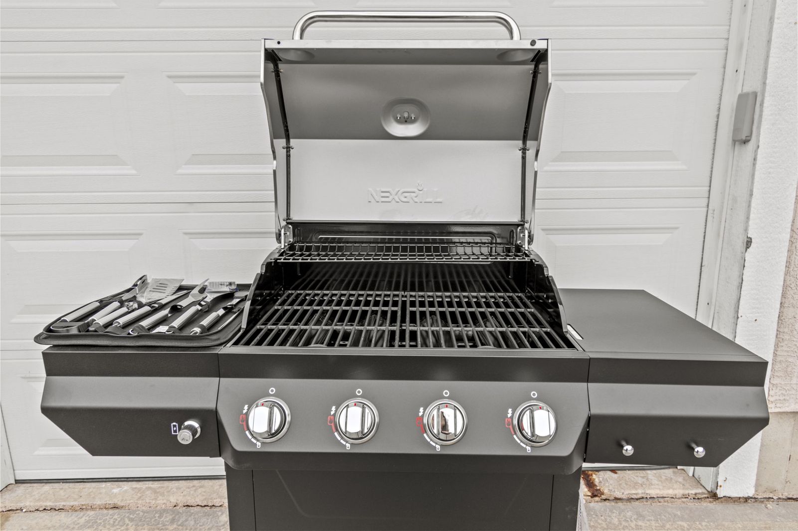 Gas grill and camp chairs by the garage